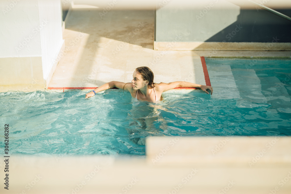 Young attractive woman in the pool relaxing