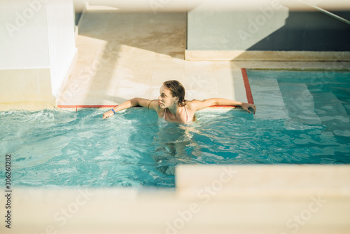Young attractive woman in the pool relaxing