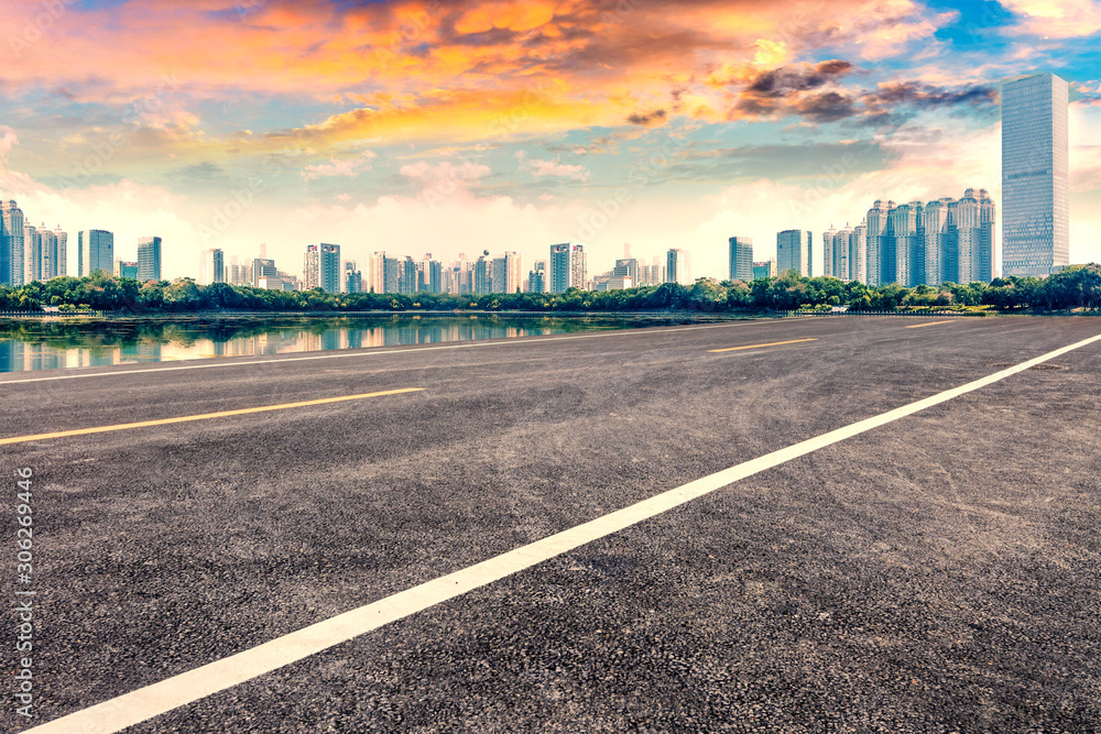 Empty asphalt pavements and modern urban landmarks in the setting sun Empty asphalt pavements and modern urban landmarks in the setting sun