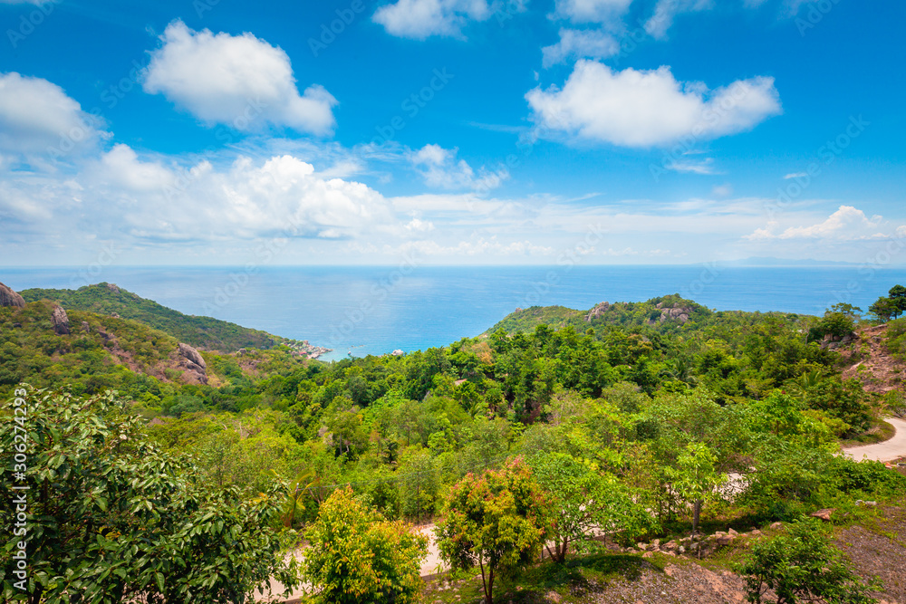 Natural Landscape View of Stone Mountain and Tropical Beach against Blue Sky and Clouds Natural Landscape View of Stone Mountain and Tropical Beach against Blue Sky and Clouds