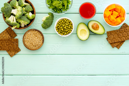Healthy food. Vegatables and fruits on green wooden background top view frame copy space