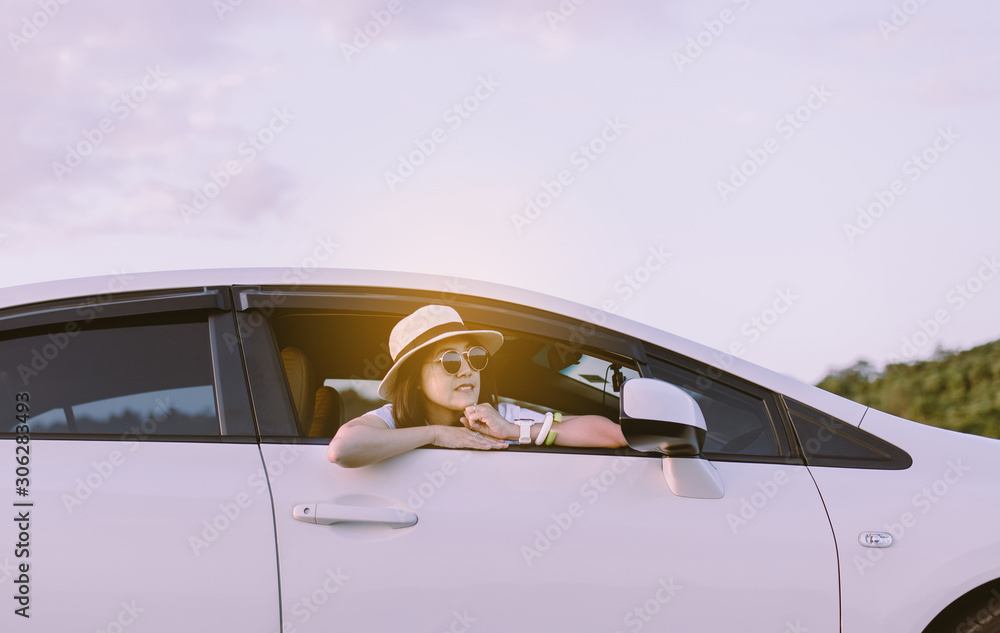 Hipster asian woman wearing hat and sunglasses sitting in her car at outdoor,Relaxing time,Positive thinking