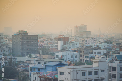Dusty sunrise in Mandalay Myanmar downtown city skyline.