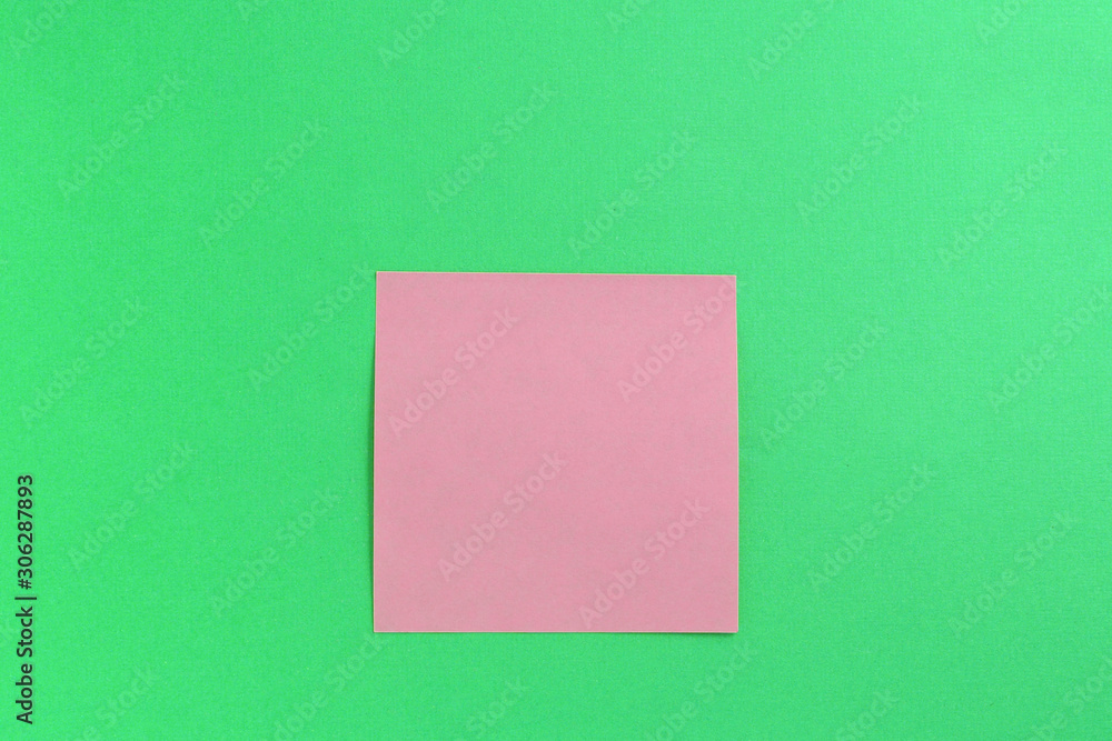 Empty pink sticker note on a green background. Business concept, horizontal mock-up Empty pink sticker note on a green background. Business concept, horizontal mock-up