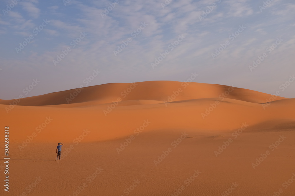A man in front of giant sand dunes in the desert near Riyadh, Saudi Arabia