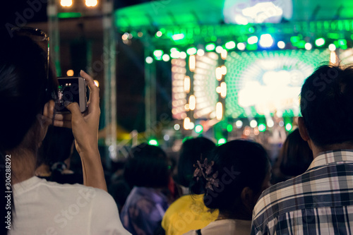People use mobile phones to live or take pictures at concerts  with bright lights at night.