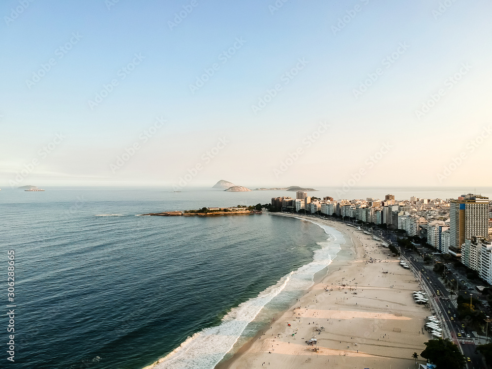 Obraz premium aerial drone view of Copacabana beachs during late afternoon,, some shadows can be seen on the sand. Rio de Janeiro, Brazil