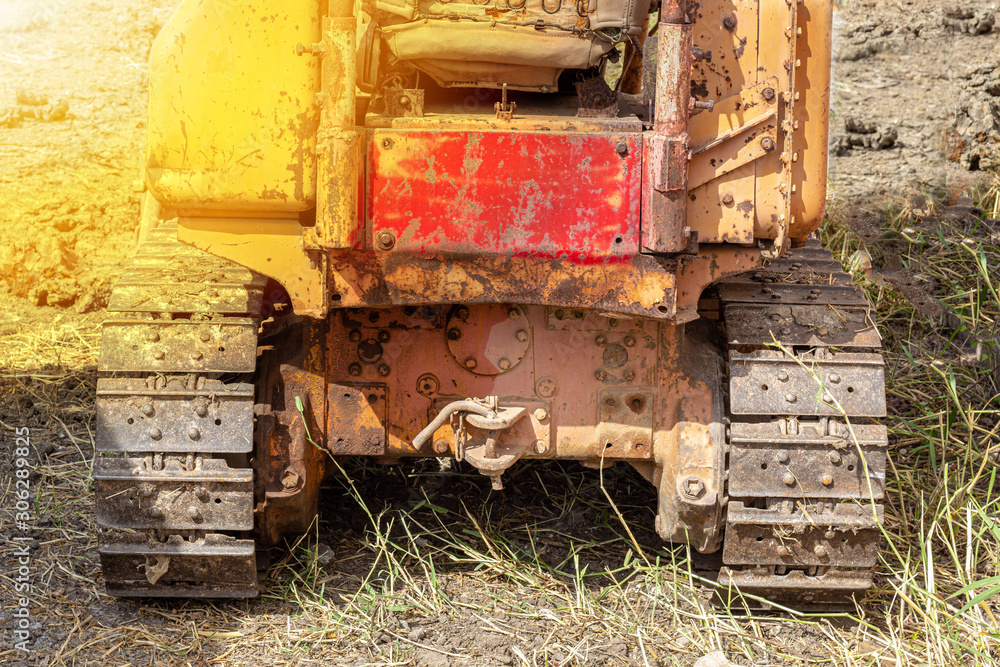 .Old yellow-tone tracked tractors, heavy-duty