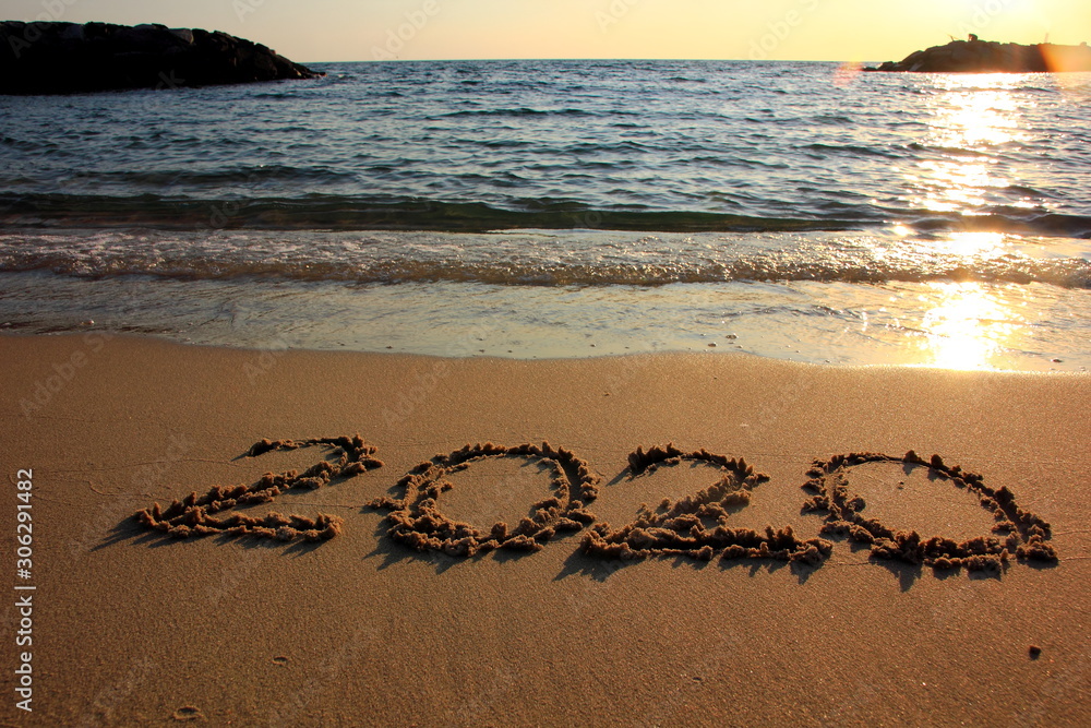 Fototapeta premium Happy New Year 2020 is coming concept on the sunset and tropical ocean beach lettering.