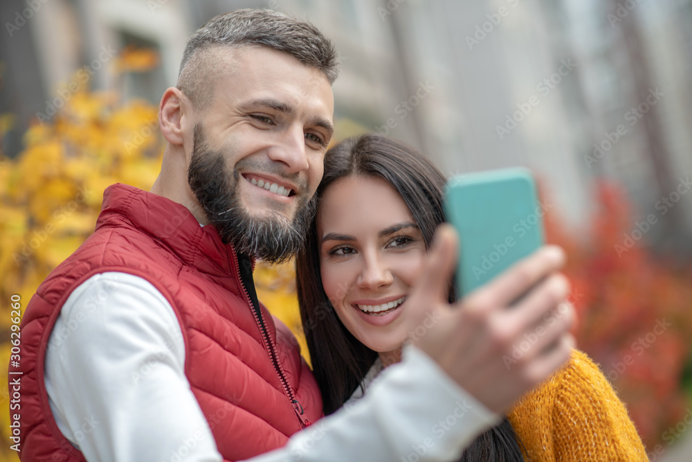 Faces of a joyful young couple taking photos together Faces of a joyful young couple taking photos together