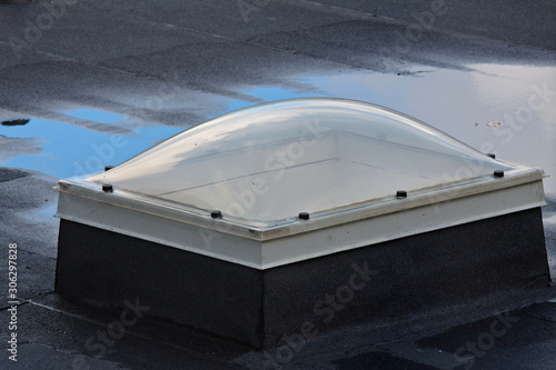 A dirty skylight window on a wet roof after rain shower