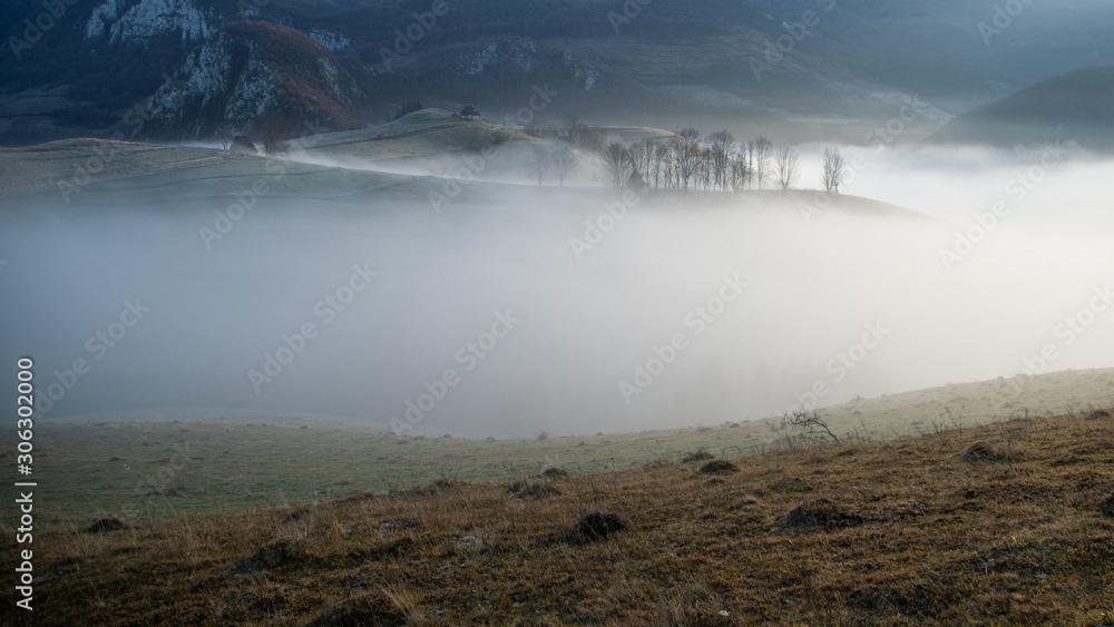 Alpine sea in the mountains. Dumesti a village from Romania cover in fog.