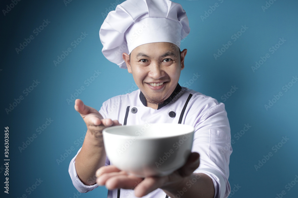 Asian Male Chef Shows Empty White Bowl, Presenting Something, Copy Space Asian Male Chef Shows Empty White Bowl, Presenting Something, Copy Space