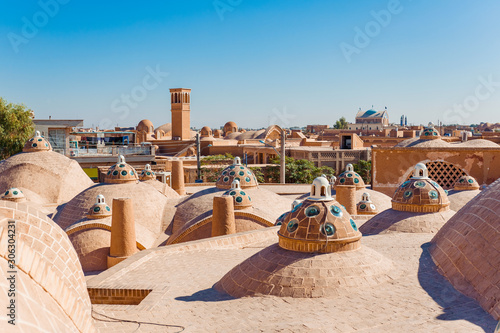 Panoramic roof view of the city of Kashan, Iran. The roof of Sultan Amir Ahmad Bathhouse, historic building's domes and windcatchers on the background of clear blue sky photo