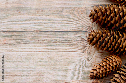 Brown pine cones on a wooden background . Selective focus. Decorative Christmas background.