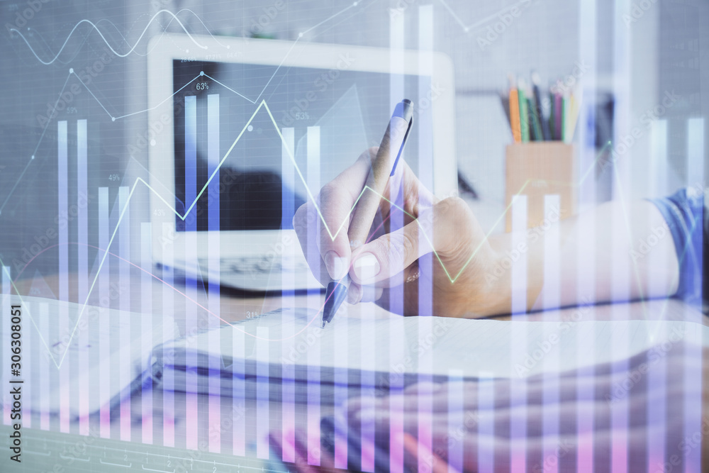 Financial forex charts displayed on woman's hand taking notes background. Concept of research. Double exposure Financial forex charts displayed on woman's hand taking notes background. Concept of research. Double exposure