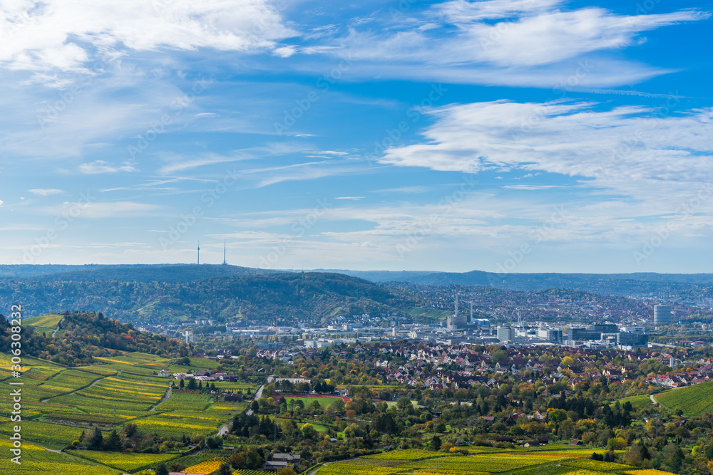 Germany, Stuttgart city houses, industry, tv tower and cityscape surrounded by hills and mountains with blue sky, aerial view above skyline