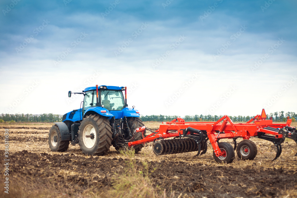 Modern tractor in the field during planting. The concept of agricultural industry. Modern tractor in the field during planting. The concept of agricultural industry.
