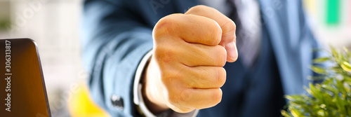 Male clenched fist in suit at office closeup