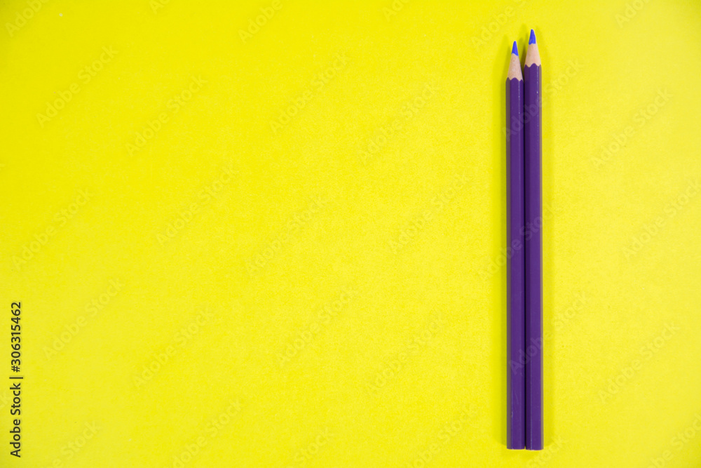 Indigo and purple color pencils on vibrant yellow background Indigo and purple color pencils on vibrant yellow background