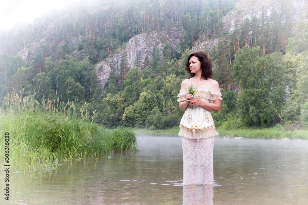 Beautiful young woman on the river in the morning fog Beautiful young woman on the river in the morning fog