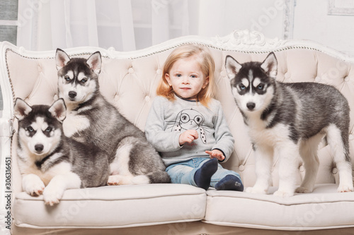 blonde girl with Husky puppies