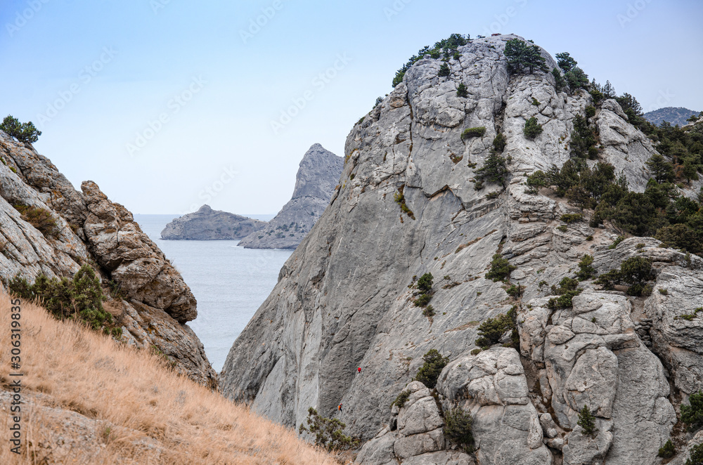 Mountain landscape by the sea. Travel to the sea, rock steep slope and mountain vegetation.