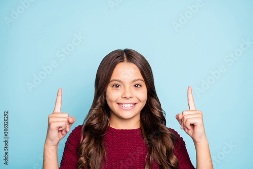 Close up photo of cheerful positive toothy beaming preteen pointing up wavy to draw you attention to sales isolated vivid blue color background