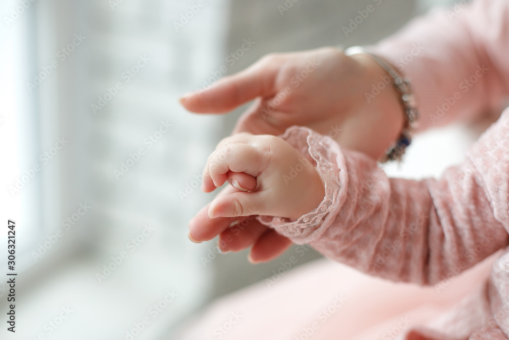 Naklejka premium Newborn baby holds mom by the finger.Tiny newborn infant male or female baby hand holding mother finger. Mother holding her newborn child. Family maternity, tenderness, parenthood, responsibility conc
