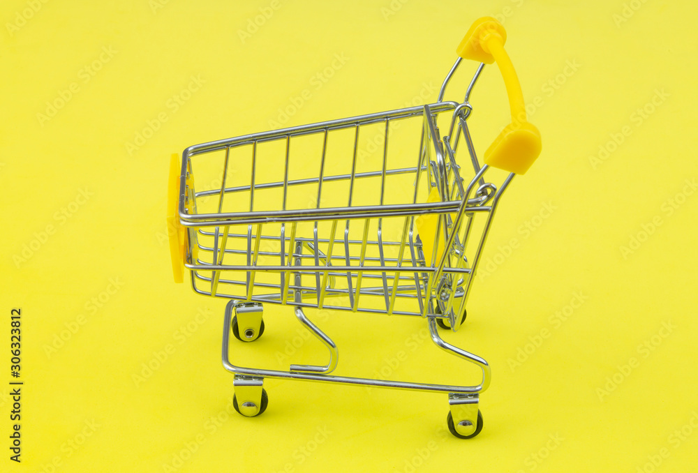 Yellow shopping cart or trolley on yellow background Yellow shopping cart or trolley on yellow background