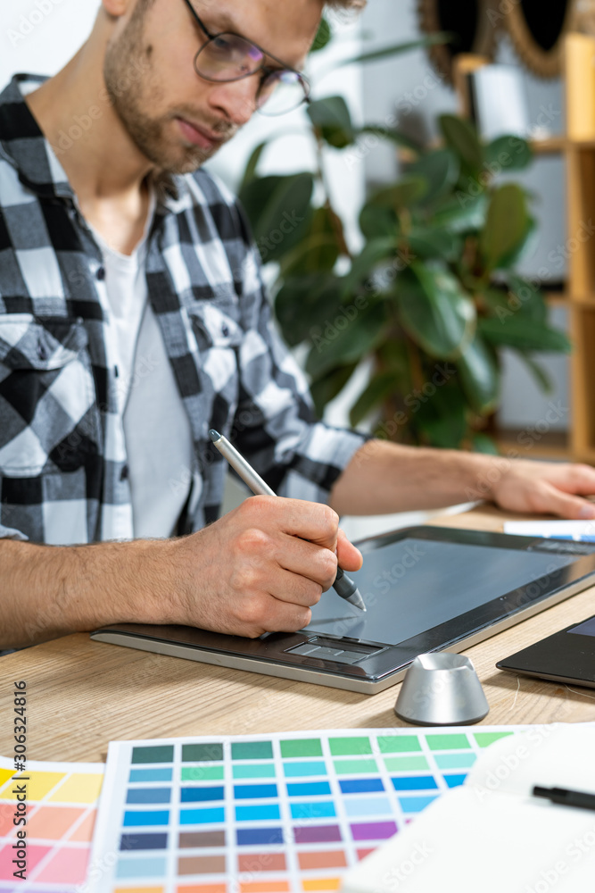 Young adult worker working with graphic tablet in office Young adult worker working with graphic tablet in office