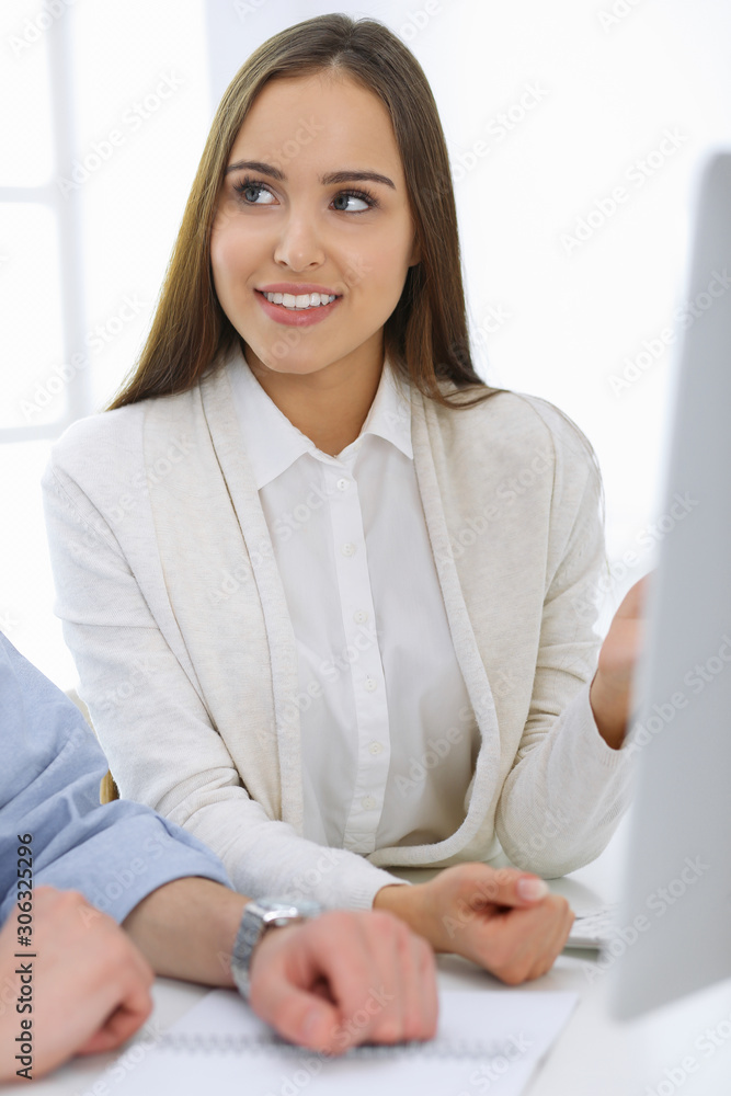 Business woman and man sitting and working with computer in office. Colleagues discussing something at meeting. Corporate teamwork and partnership concepts Business woman and man sitting and working with computer in office. Colleagues discussing something at meeting. Corporate teamwork and partnership concepts