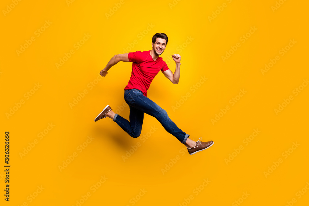 Full length photo of cheerful youth guy jump have fun on spring time holidays wear casual style clothing isolated over yellow color background