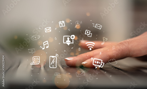 Business woman hand typing on keyboard with drawn application icons around