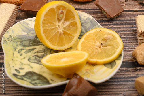 sliced lemon on a saucer and on a wooden background. Close up.