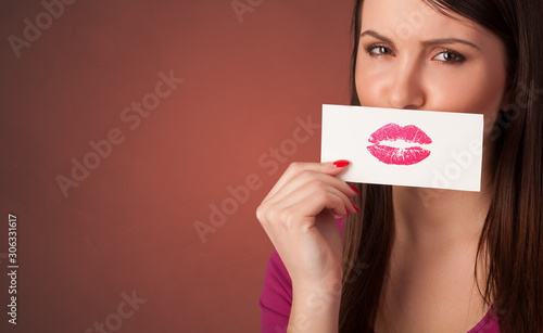 Person smiling with a card on the front of his mouth with a red lips on it