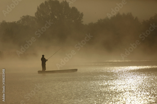 Fisherman on the boat during morning fog on the Soderica Lake, Croatia