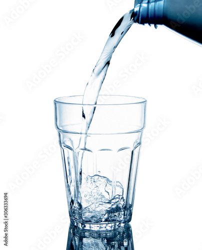 Pouring clean drinking water on a transparent glass. For health concepts. Isolated white background