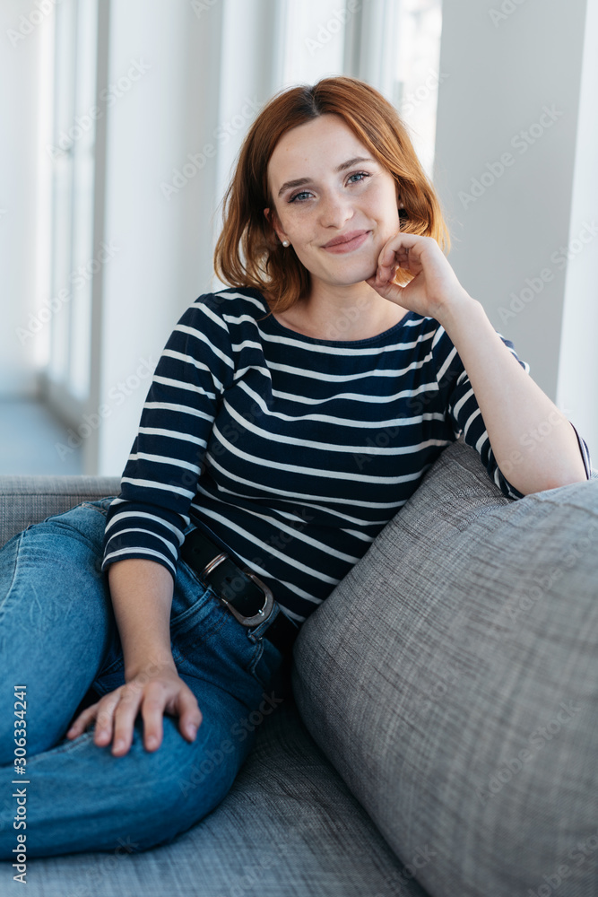 Pretty young redhead woman relaxing on a couch Pretty young redhead woman relaxing on a couch