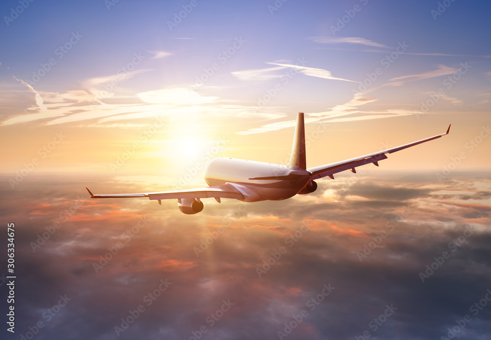 Pasażerski samolot handlowy latający nad chmury w świetle słońca. Pojęcie szybkiej podróży, wakacji i biznesu. <span>plik: #306334675 | autor: Jag_cz</span>