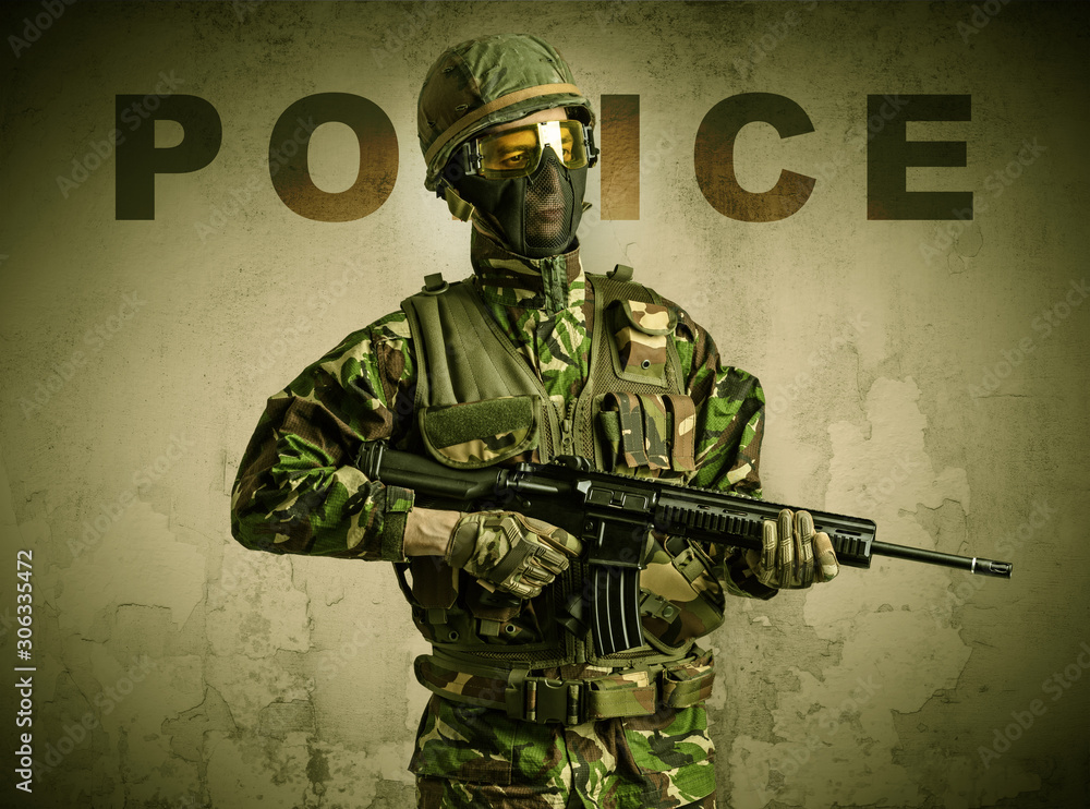 Uniformed armed soldier with damaged wall background Uniformed armed soldier with damaged wall background