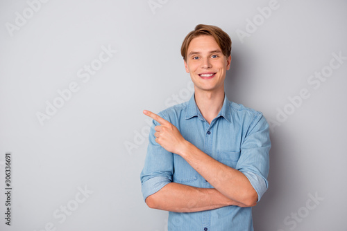 Portrait of confident cool guy promoter point index finger copypace pick tips ads promotion wear good look outfit isolated over grey color background photo