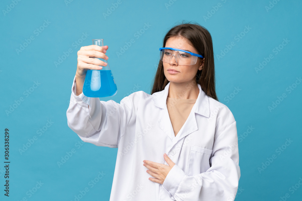 Young woman over isolated blue background with a scientific test tube Young woman over isolated blue background with a scientific test tube