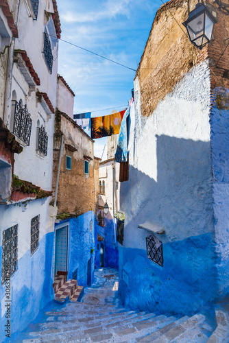 Narrow street of Chefchaouen city in Morocco with blue walls and pretty windows vertical © leelook