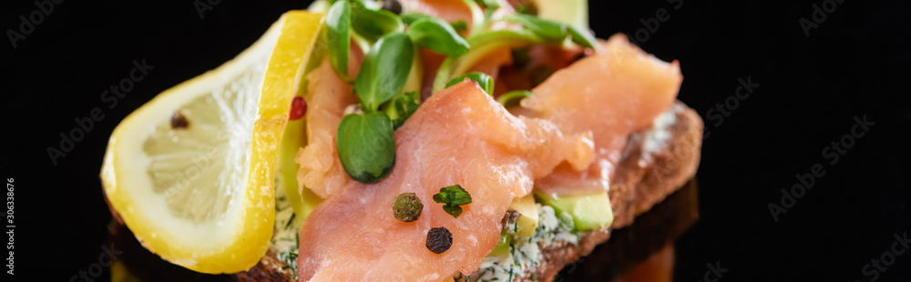 panoramic shot of lemon near salmon on danish smorrebrod sandwich on black panoramic shot of lemon near salmon on danish smorrebrod sandwich on black