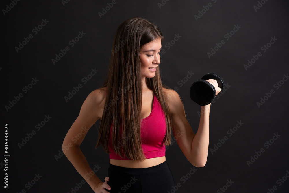 Young sport woman making weightlifting over isolated black background Young sport woman making weightlifting over isolated black background