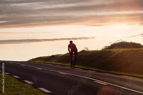 cyclist climbing a slope at sunset © Image'in
