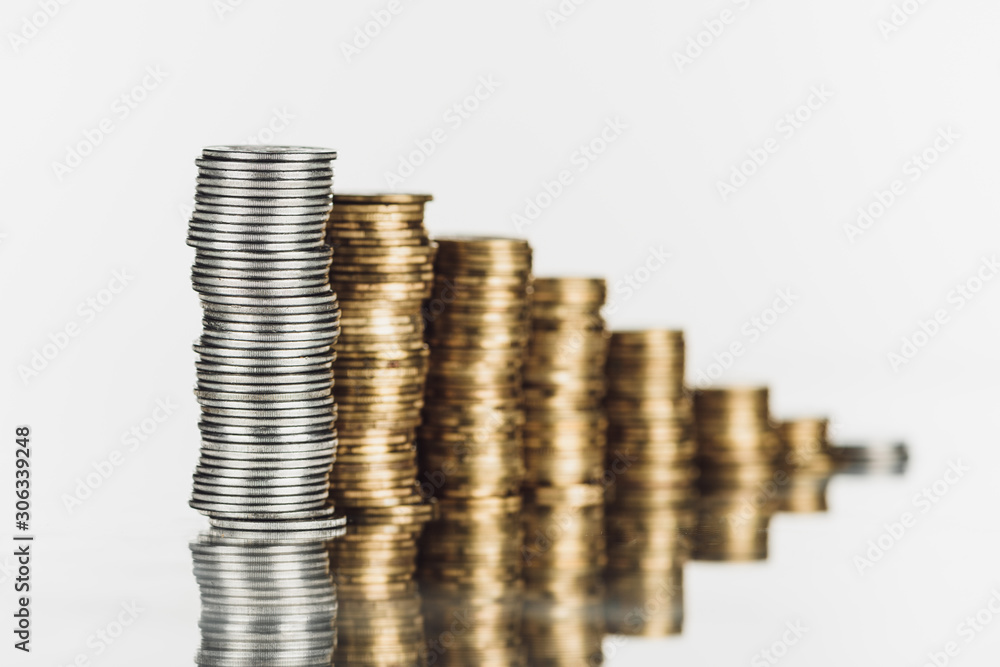 selective focus of stacked silver and golden coins on surface with reflection isolated on white selective focus of stacked silver and golden coins on surface with reflection isolated on white