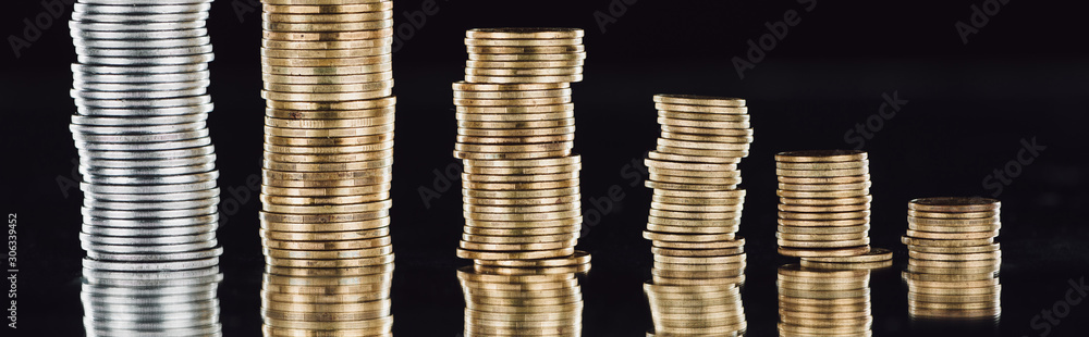 panoramic shot of stacked silver and golden coins on surface with reflection isolated on black panoramic shot of stacked silver and golden coins on surface with reflection isolated on black