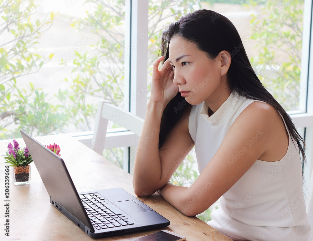 Beautiful asian woman sitting alone in coffee shop with computer on table , Beautiful asian woman sitting alone in coffee shop with computer on table ,